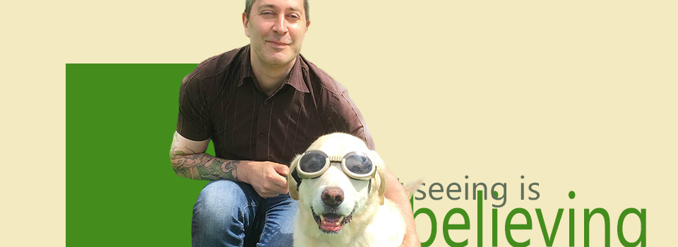 stuwilliams.co.uk header image. Stu Williams with his guide dog Brett, who's wearing 'dog-goggles' (Brett, not Stu!). Text reads 'seeing is believing' (because, yes the guide dog is wearing goggles!)